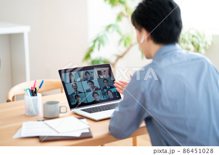 リモートワークでオンライン会議をする男性  86451028