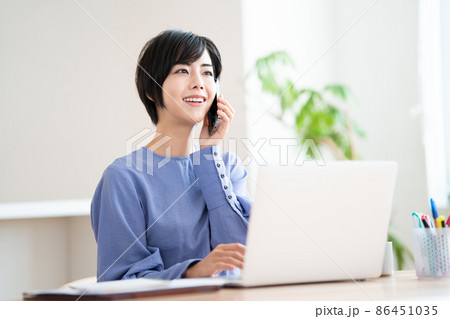 電話をしながら在宅勤務をする女性 電話をしながら在宅勤務をする女性 86451035