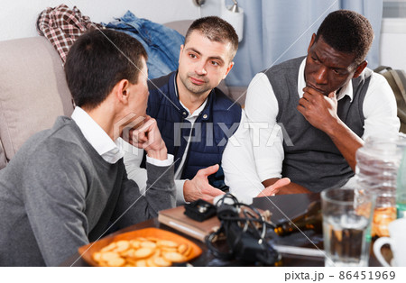 Three men are drinking beer and arguing in time rest together 86451969