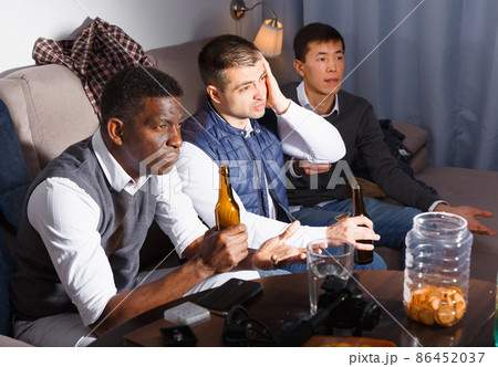 Upset males emotionally watching tv 86452037