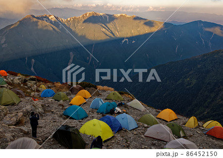 南アルプス・北岳肩の小屋のテント場と夕暮れの鳳凰三山 86452150