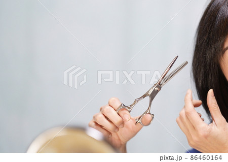 セルフカットする女性 ハサミを持って自分の髪を切る女性 目無し 顔無し セルフカットする女性 ハサミを持って自分の髪を切る女性 目無し 顔無し 86460164