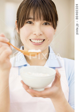 おかゆを食べさせる女性介護福祉士 86460304