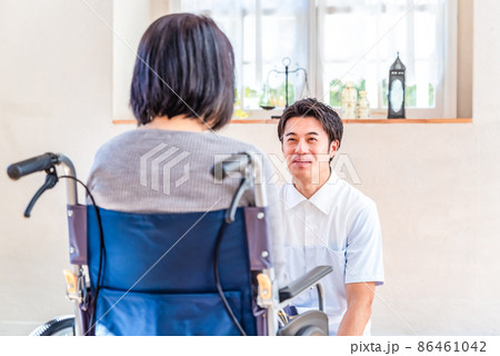 リハビリテーションセンター　女性入居者と状況を確認する男性介護士 86461042