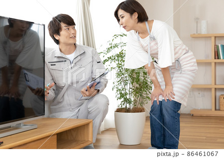 住宅点検　テレビの配線を確認する男性と主婦 86461067