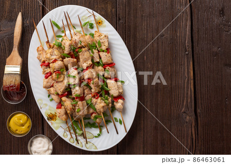 Meat kebabs on a large platter with sauces and herbs Meat kebabs on a large platter with sauces and herbs 86463061