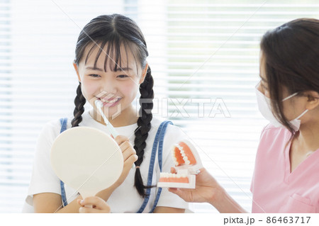 歯科で歯磨きの指導を受ける女の子 歯科で歯磨きの指導を受ける女の子 86463717