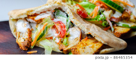 Mediterranean style pitta prepared with spicy chicken, cucumber, tomato, salad and mayo sauce Mediterranean style pitta prepared with spicy chicken, cucumber, tomato, salad and mayo sauce 86465354