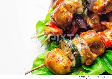 Grilled skewers with chicken, zucchini, mushrooms, peppers and onions served on iceberg lettuce Grilled skewers with chicken, zucchini, mushrooms, peppers and onions served on iceberg lettuce 86465495