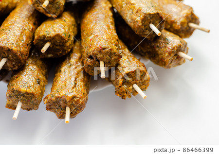 Minced and shaped lamb kebabs with chilli and coriander prepared for grill 86466399
