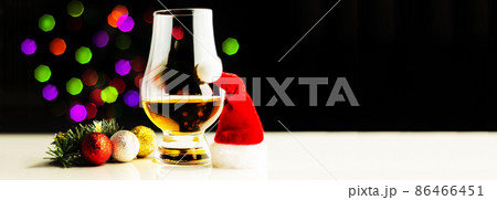 single malt  whisky in tasting glass on christmas background, colorful bokeh 86466451