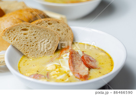 Traditional polish sour soup with sausage and eggs in ceramic bowl 86466590