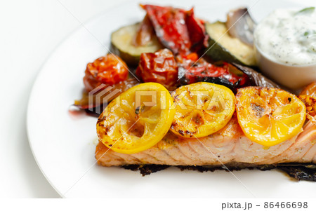 Grilled salmon fillet served with roasted vegetables with cucumber and dill sauce Grilled salmon fillet served with roasted vegetables with cucumber and dill sauce 86466698
