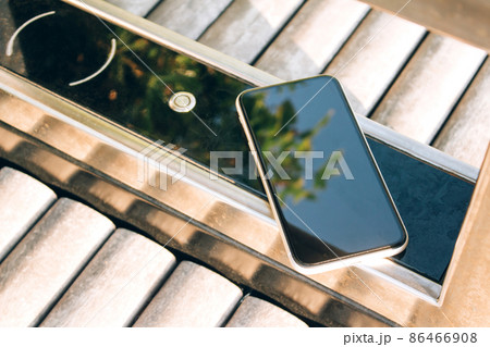 Charging smartphone using wireless charging pad on smart bench with free city charger and wifi. Wireless charging technology. Tourist tips 86466908
