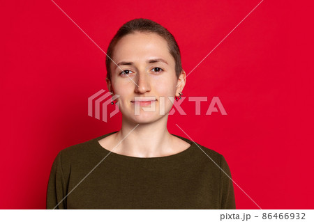 Portrait of young smiling woman, student with short hair in dark sweater isolated on red background. Concept of emotions, studying, ad Portrait of young smiling woman, student with short hair in dark sweater isolated on red background. Concept of emotions, studying, ad 86466932