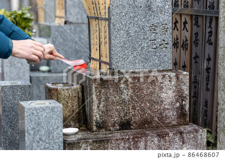 お墓参りに来てお墓の掃除をしている男性 86468607