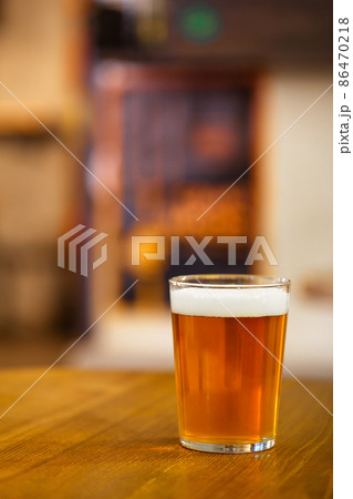 Glass of delicious draught craft beer on wooden table 86470218