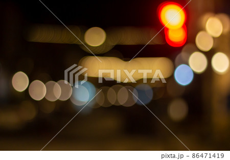 Out of focus defocused blurred bokeh of cars and traffic lights at night on city street. Out of focus defocused blurred bokeh of cars and traffic lights at night on city street. 86471419