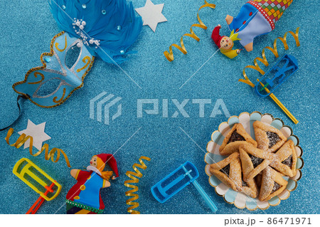 Jewish holiday Purim background with hamantaschen or hamans ears cookies, carnival mask and noisemaker 86471971