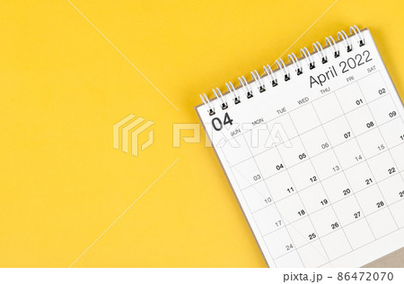 April 2022 desk calendar on yellow background with empty space. April 2022 desk calendar on yellow background with empty space. 86472070
