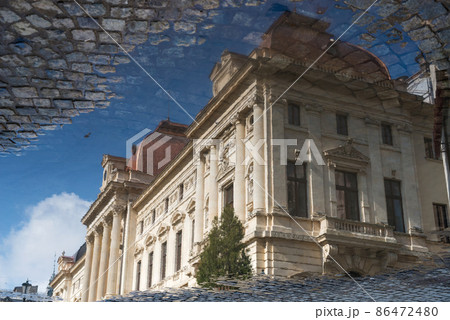 After rain in Bucharest, Romania - reflection of the house in a puddle - upside down image After rain in Bucharest, Romania - reflection of the house in a puddle - upside down image 86472480