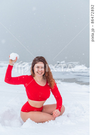 Caucasian woman in a red tracksuit plays snowballs. Caucasian woman in a red tracksuit plays snowballs. 86472892