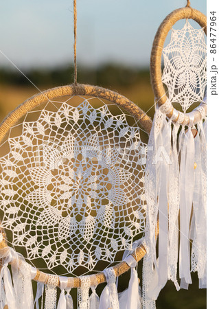 White cotton dreamcatcher at natural background, soft selective focus, toned 86477964