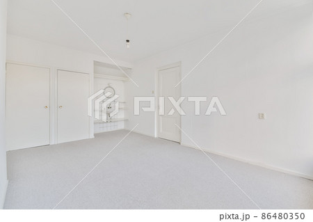 a set of white sink and mirror on the wall in the corner of an empty room with grey carpeting room a set of white sink and mirror on the wall in the corner of an empty room with grey carpeting room 86480350