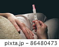 A woman sees a positive pregnancy test result. 86480473