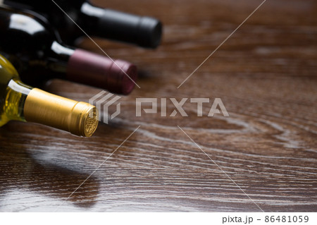Various Wine Bottles on a Reflective Wood Surface Abstract. 86481059
