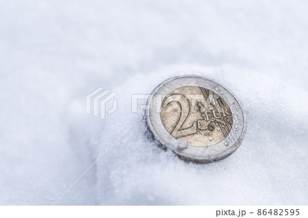 2 euro coin that fell on the snow. A lost old EU coin. Money issued in 2000. Soft focus, copy space 2 euro coin that fell on the snow. A lost old EU coin. Money issued in 2000. Soft focus, copy space 86482595