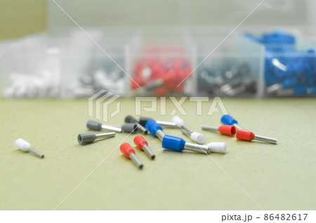 Coloured crimp terminals for different wire sizes. Copper sleeves for crimping electrical cables. Ferrules. Selective focus, copy space 86482617