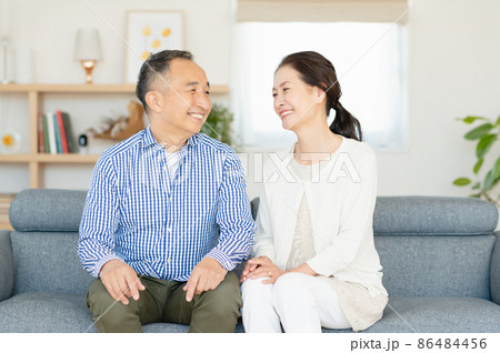 ソファでくつろぐシニア夫婦 86484456