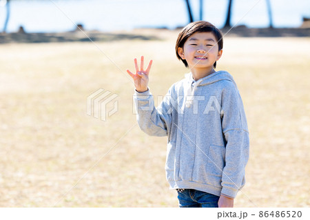 指を4本立てている男の子 86486520