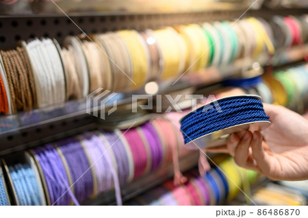 Male hand choosing Ric Rac ribbon in craft shop Male hand choosing Ric Rac ribbon in craft shop 86486870