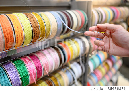 Male hand choosing Ric Rac ribbon in craft shop 86486871
