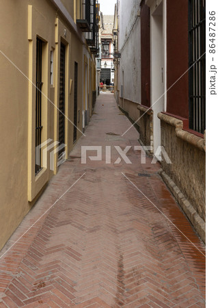 建物に挟まれた石畳の小径と街灯・スペイン・セビージャ 86487286