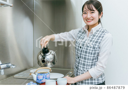お茶をくむ会社員の女性 86487879