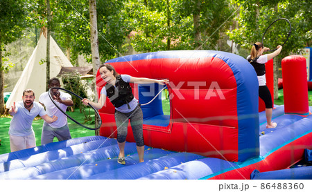 Woman competing to collect hoops on inflatable playground 86488360
