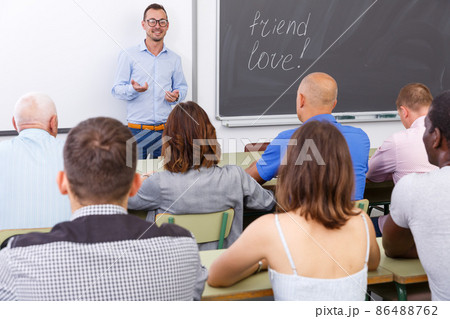 Adult lecturer talking to mixed age students 86488762
