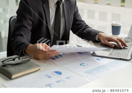 The businessman hand sits at their desks and calculates financial graphs showing the results of their investments planning the process of successful business growth 86491074