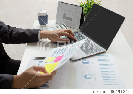 The businessman hand sits at their desks and calculates financial graphs showing the results of their investments planning the process of successful business growth 86491075