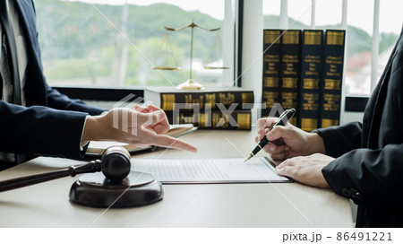 Male lawyers or a judge counseling clients about judicial justice and prosecution with scales, judges gavel, legal documents legal services concept 86491221