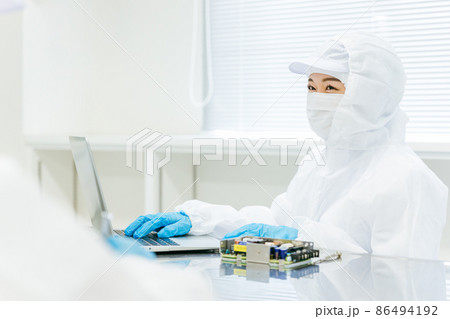 クリーンルームで精密機器を扱う女性 86494192