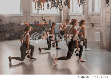 Group of people exercising with kettlebells at gym Group of people exercising with kettlebells at gym 86494994