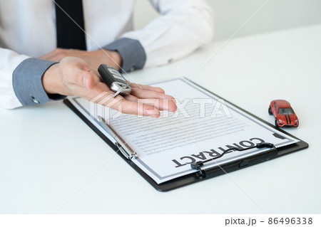 Car dealer businessman holding a car key. Car loan and insurance concept Car dealer businessman holding a car key. Car loan and insurance concept 86496338