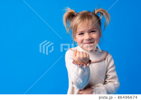 Naughty little girl over the blue background Naughty little girl over the blue background 86496674