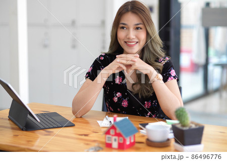 Business lady, real estate agent sitting at her workplace Business lady, real estate agent sitting at her workplace 86496776