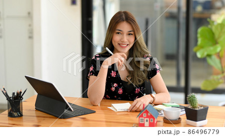 Female real estate realtor or house insurance broker sitting at her office. Female real estate realtor or house insurance broker sitting at her office. 86496779