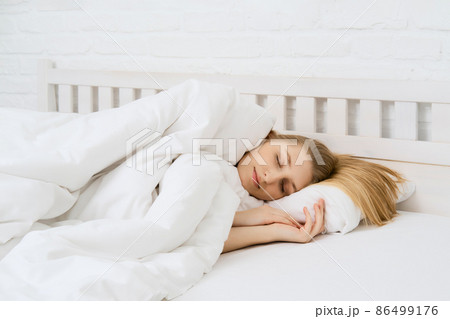 Young beautiful woman sleeping in bed 86499176